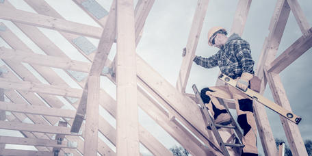 Carpentiere al lavoro su una struttura del tetto in un cantiere edile