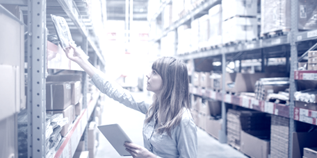 Employée réalisant l’inventaire de marchandises stockées dans un dépôt